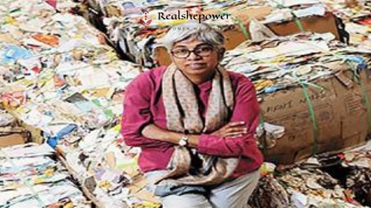 The Founder Of Ngo Saahas To Saahas Zero Waste (Szw), A Social Enterprise, Wilma Rodrigues Is Sitting On A Pile Of Paper Waste. She Is Posing Smartly Towards The Camera In Her Short Pink Kurta And Grey Pant.