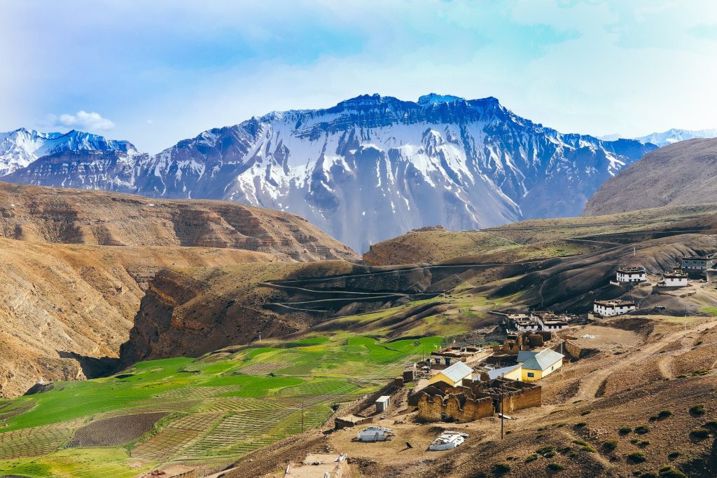 Green Grass Field Near Snow Covered Mountain