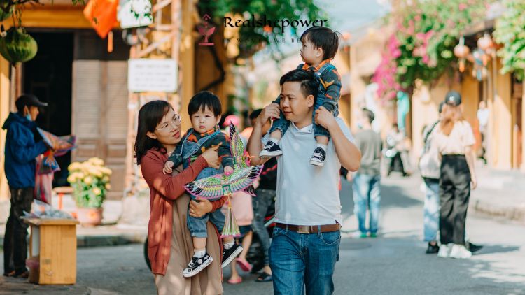 Understanding Relationship With Your Parents To Understand Attachment Styles For Better Relationships. Here A Couple Is With Their Two Children Walking On The Street Happily.