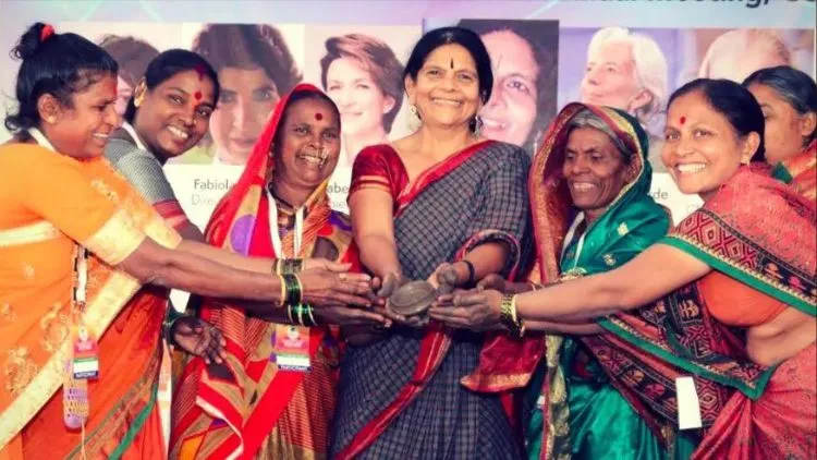 The Power Of Benevolence Blended With Valor: Chetna Gala Sinha, Founder Of First Rural Women Co-Operative Bank 3 Chetna Gala Sinha, Founder Of India'S First Rural Women'S Cooperative Bank, Standing With Rural Women With Their Hands Clasped With One Another As A Sign Of Togetherness And Inclusion On The Stage Of An Event.