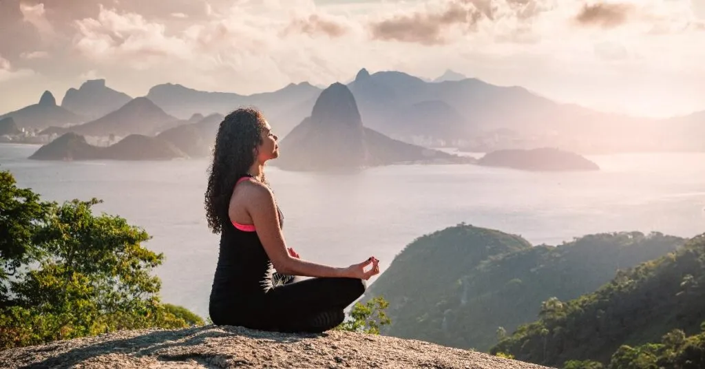 Omg! This Epic Himalayan Trek Will Challenge You &Amp; Change You Forever 2 A Woman Sitting On A Rock With Mountains In The Background Forget Maldives! Uttarakhand Has The Most Breathtaking Yoga Retreats (Seriously)